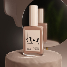 Nagellack-Flacon auf Hocker vor einem Spiegel in gedämpftem Licht